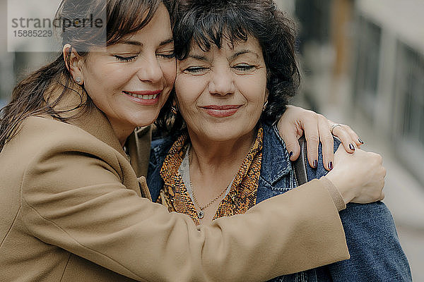 Porträt einer glücklichen Frau  die ihre Mutter umarmt