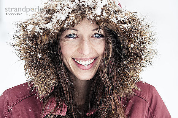 Porträt einer lachenden jungen Frau mit blauen Augen im Winter