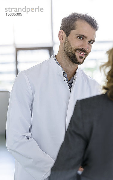 Porträt eines selbstbewussten Arztes bei einem Treffen mit einer Geschäftsfrau im Krankenhaus