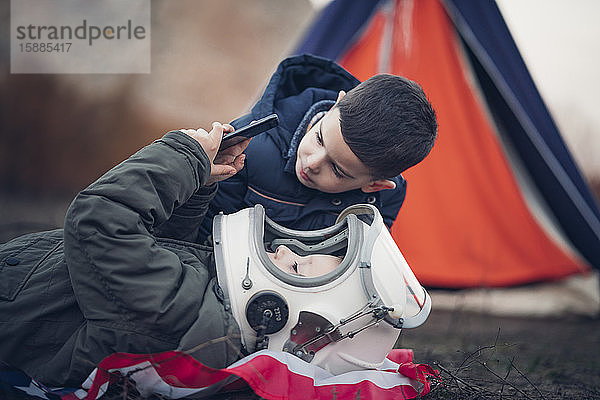 Zwei Jungen sehen sich draußen ein Smartphone an