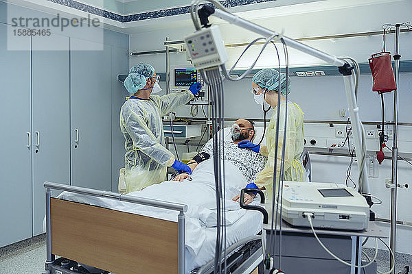 Ärzte  die Patienten auf der Notfallstation eines Krankenhauses betreuen  schauen auf den Bildschirm
