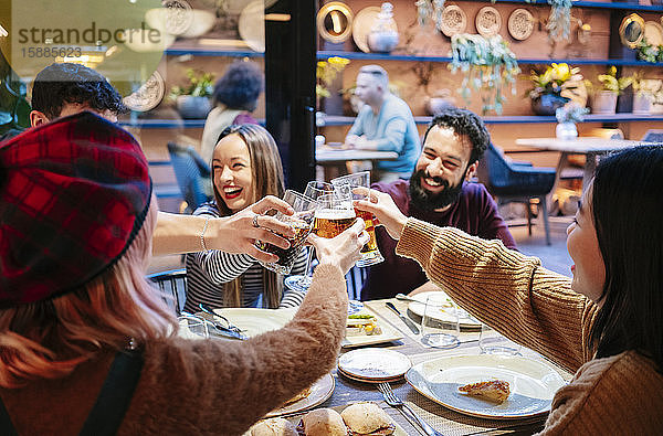 Freunde beim Abendessen in einem schicken Restaurant  anstoßend