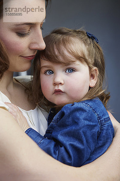 Porträt eines Kleinkindes in den Armen seiner Mutter