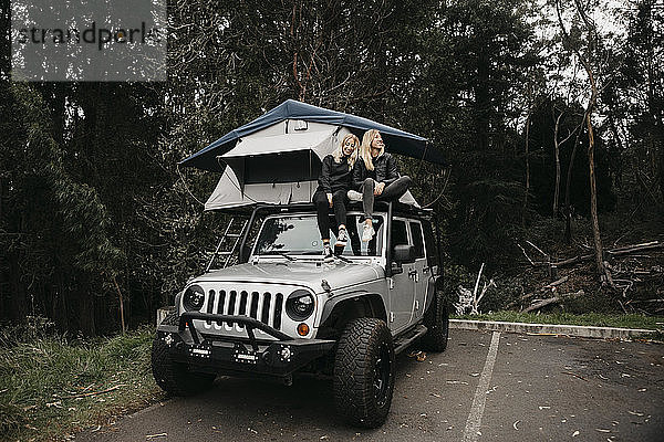 Glückliche Freundinnen sitzen im Zelt über einem Jeep im Haleakala-Nationalpark  Maui  Hawaii  USA