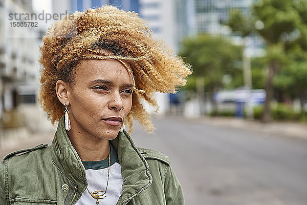 Porträt einer jungen Frau mit Afrofrisur in der Stadt