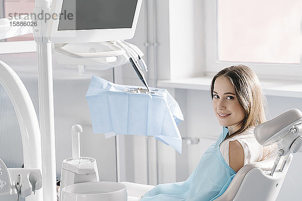 Zuversichtliche junge Frau wartet auf Behandlung in Zahnklinik