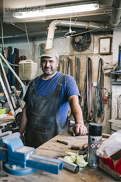 Porträt eines selbstbewussten Messermachers in seiner Werkstatt