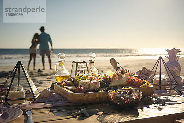 Frisches Essen auf dem Esstisch mit einem reifen Paar  das an einem sonnigen Tag aufs Meer schaut  Riviera Nayarit  Mexiko