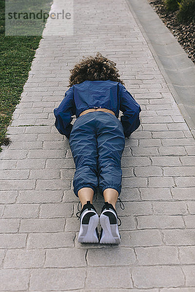 Junge Frau macht Push-Ups auf einem Weg