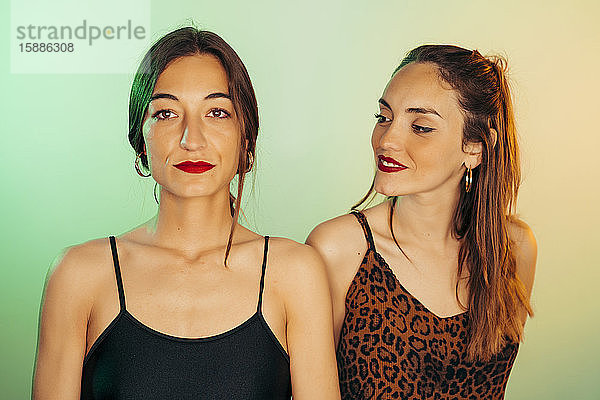 Porträt von zwei jungen Frauen vor grünem Hintergrund