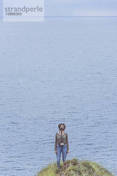 Junge Frau am Meer  mit Gasmaske