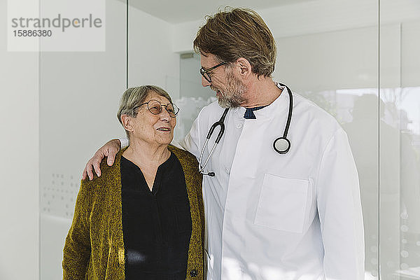Pflegender Arzt im Gespräch mit älterem Patienten in der medizinischen Praxis