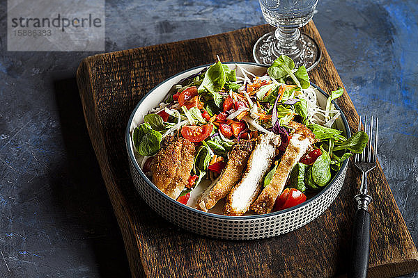 Schüssel mit verzehrfertigem Salat mit Gemüse und Hühnerschnitzel