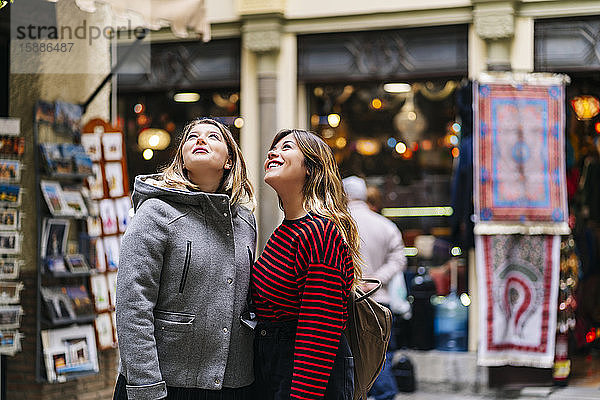 Zwei junge Frauen in der Stadt blicken auf