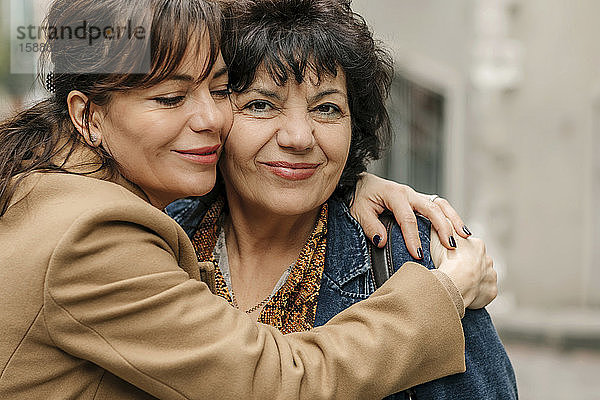 Porträt einer glücklichen Frau  die ihre Mutter umarmt