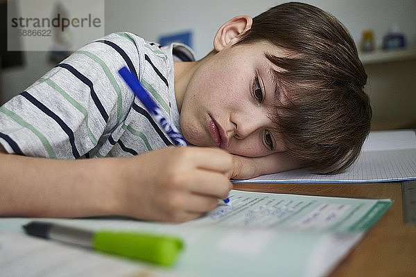 Porträt eines Jungen bei den Hausaufgaben