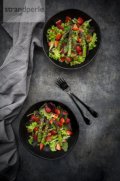 Zwei Schalen mit vegetarischem Salat mit Salat  Erdbeeren und Spargel