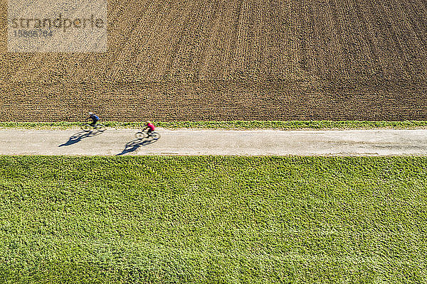 Deutschland  Baden-Württemberg  Remshalden  Luftaufnahme von zwei Radfahrern auf einem Feldweg im Frühling