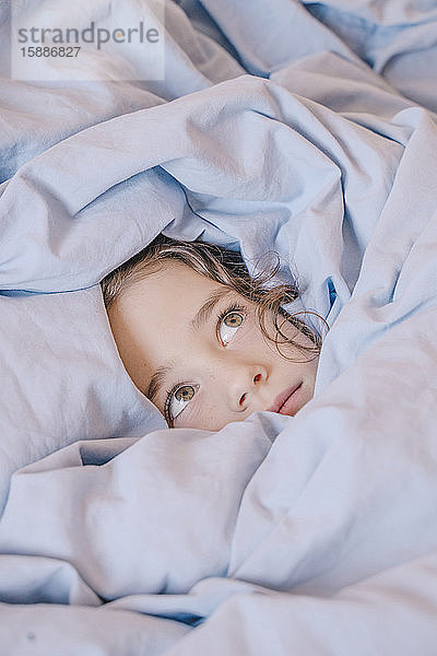 Bildnis eines ängstlichen Mädchens unter einer Decke liegend