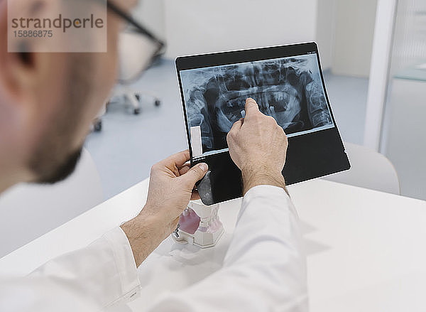 Zahnarzt  der dem Patienten die Röntgenergebnisse erklärt