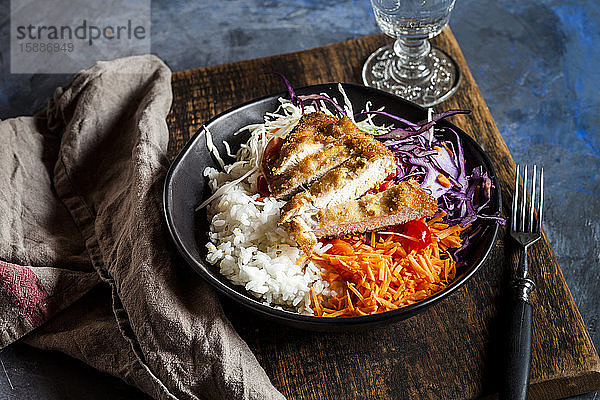 Schale mit verzehrfertigem Salat mit Weiss- und Rotkohl  Karotten  Reis und Hühnerschnitzel