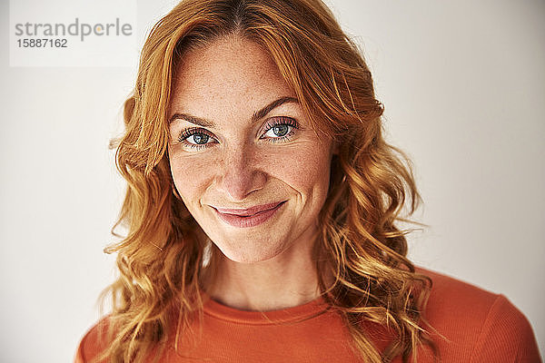 Porträt einer lächelnden rothaarigen Frau  die in die Kamera schaut