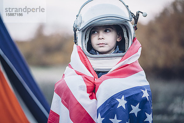 Bildnis eines kleinen Jungen mit amerikanischer Flagge und Weltraumhelm