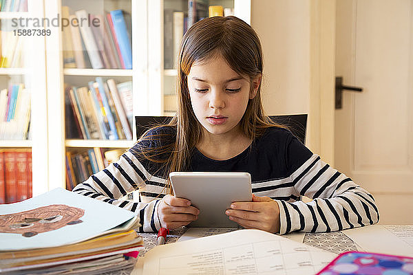Mädchen macht Hausaufgaben mit digitalem Tablett