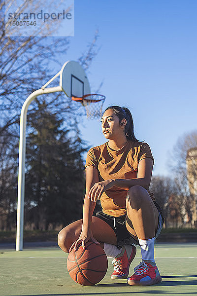 Basketballspielerin kauert auf dem Platz