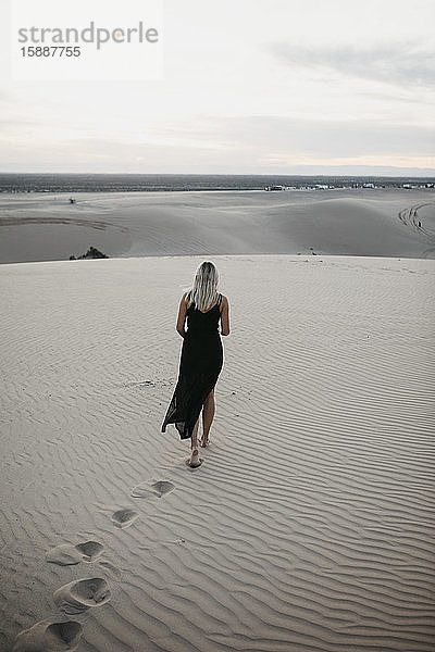 Rückenansicht einer blonden Frau  die auf einer Sanddüne geht  Algodones Dunes  Brawley  USA