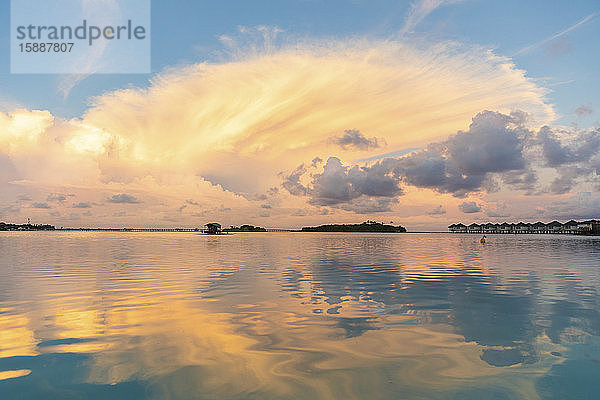 Wunderschöner Sonnenuntergang mit Wolken und Spiegelungen auf dem Wasser  Männlich  Malediven