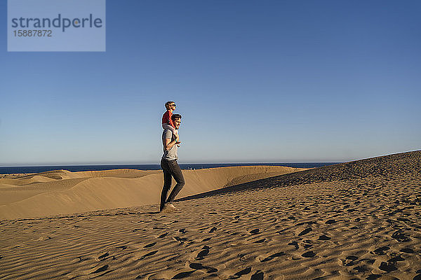 Vater trägt Tochter auf Schultern in Sanddünen  Gran Canaria  Spanien