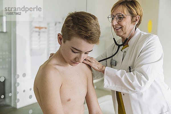 Arzt untersucht Teenager-Jungen mit einem Stethoskop
