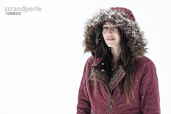 Porträt einer jungen Frau mit Kapuzenjacke im Winter