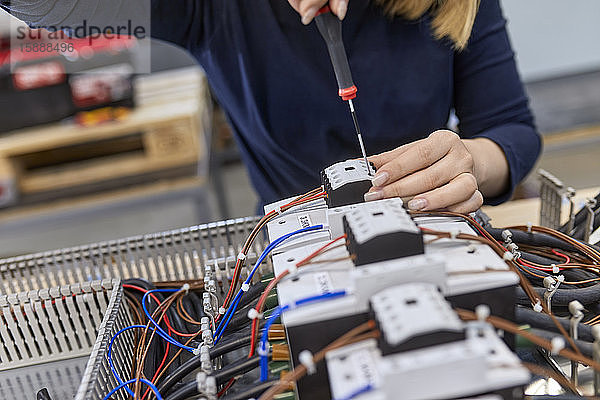 Nahaufnahme eines Elektrikers  der in einer Werkstatt an Schaltkreisen arbeitet