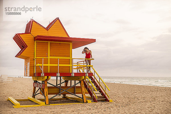 Frau im roten Badeanzug auf Rettungsschwimmerhütte in Miami Beach  Miami  Florida  USA