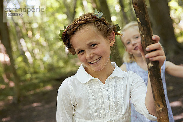Porträt eines lächelnden Mädchens im Wald mit Freund