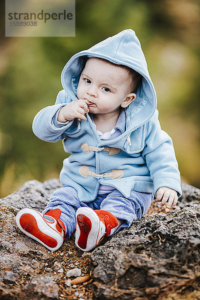 Porträt eines kleinen Jungen mit hellblauer Kapuzenjacke im Freien