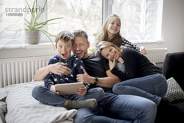 Porträt einer verspielten Familie auf der Couch zu Hause