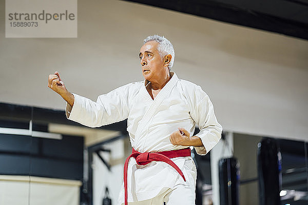 Älterer Mann übt Karate im Fitnessstudio