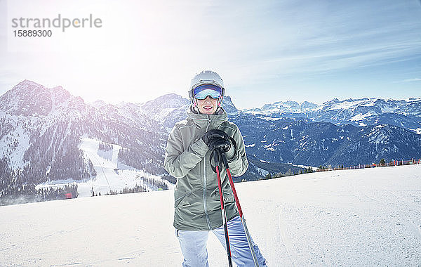 Porträt einer lächelnden Skifahrerin auf der Skipiste