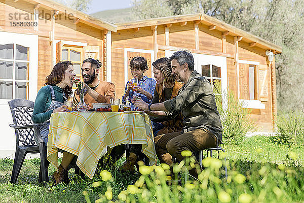 Familie und Freunde genießen ein gesundes veganes Frühstück auf dem Land