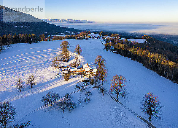 Deutschland  Bayern  Buchberg  Drohnenansicht eines Bergbauernhofes in der Winterdämmerung