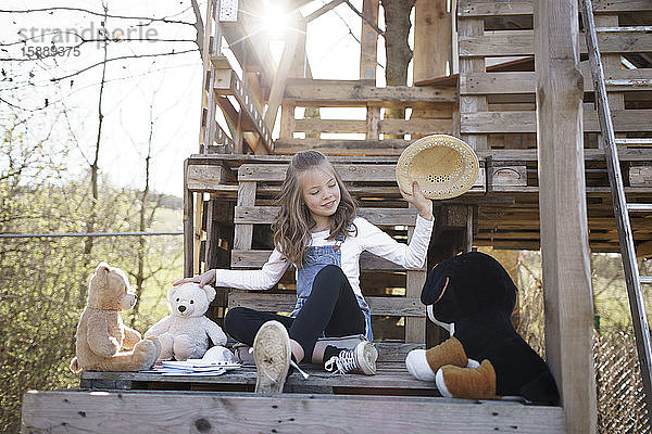 Mädchen spielt mit ihren Teddybären im Baumhaus