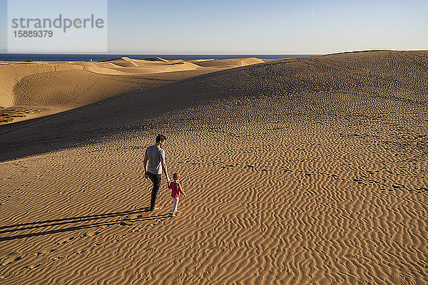 Vater und Tochter gehen Hand in Hand in den Sanddünen  Gran Canaria  Spanien