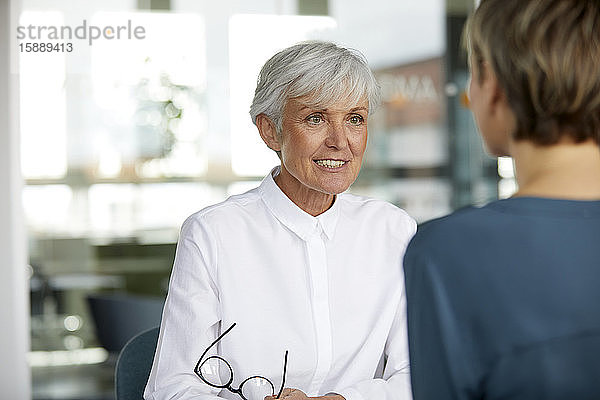 Porträt einer hochrangigen Geschäftsfrau im Gespräch mit ihrem Amtskollegen