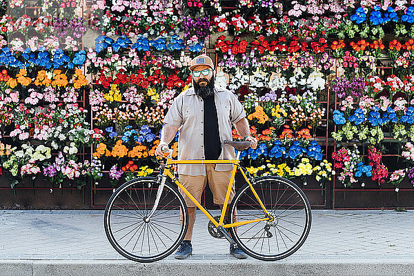 Porträt eines bärtigen Mannes mit Fixie-Bike und verspiegelter Sonnenbrille