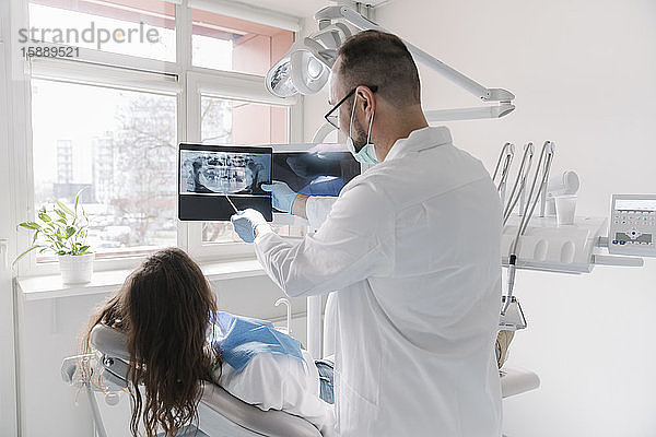 Junge Frau wird in der Klinik zahnärztlich behandelt  Arzt erklärt Röntgenaufnahme