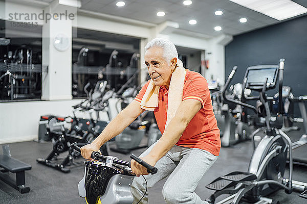 Älterer Mann übt an Übungsgerät im Fitnessstudio