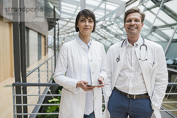 Zwei Ärzte stehen im Atrium und halten ein digitales Tablett